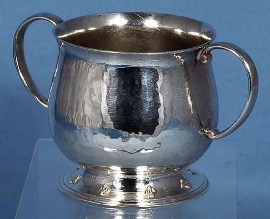 A George V Arts & Crafts silver two handled cup, Width to handles 5”/128mm Height 3”/78mm Weight 7oz/197grms